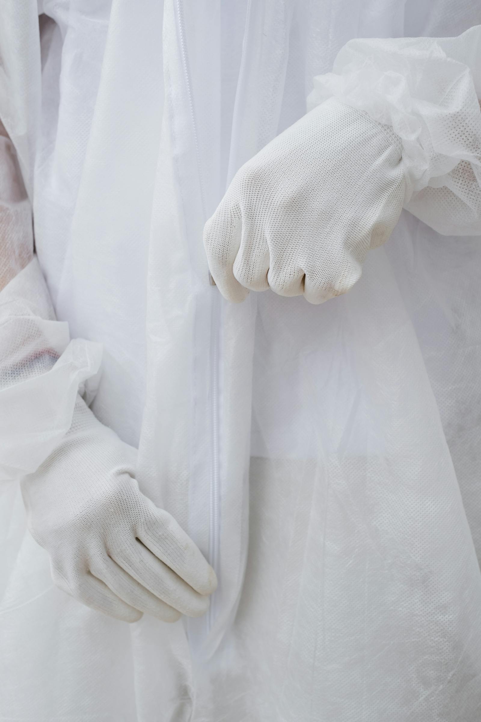 Close-up of protective hazmat suit gloves during safety preparation